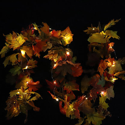 A 1.8m LED light-up autumn pumpkin and maple leaf vine garland glowing warmly draped across a wooden front door.