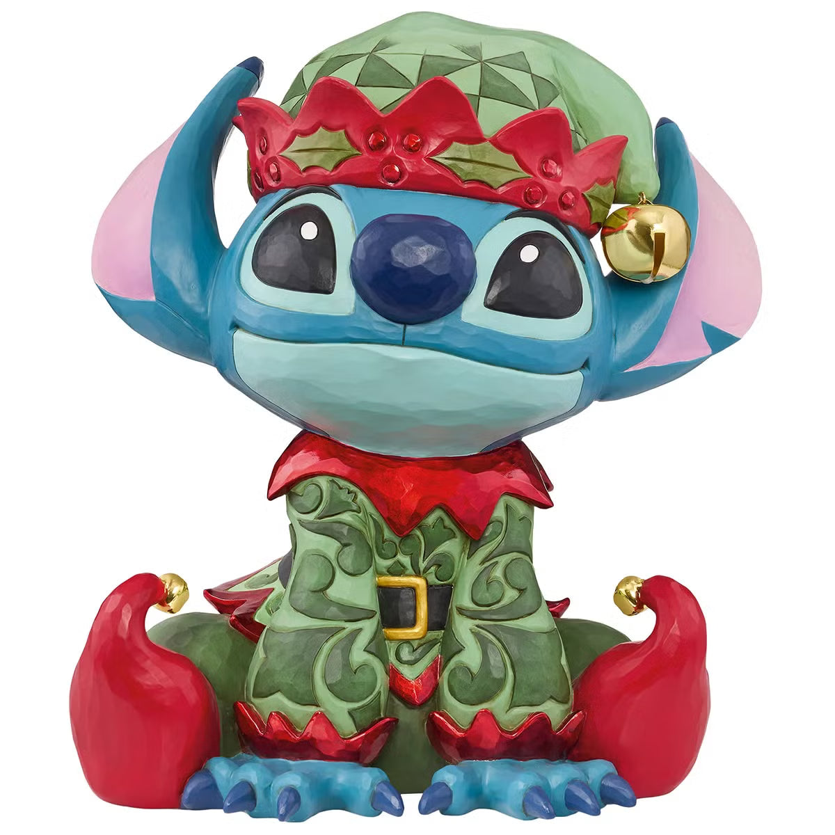 Front angle view of a 14-inch hand-painted Disney Elf Stitch statue by Jim Shore featuring green elf hat, jingle bells, and detailed stone resin folk patterns on a wooden table.