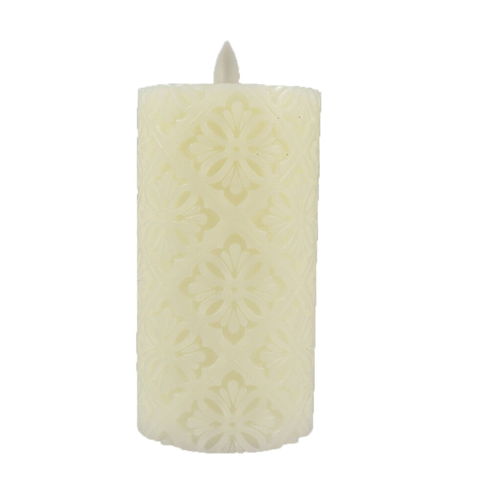 A 15cm white paraffin wax flameless LED candle featuring an intricate hollow flower pattern glowing softly on a decorative table.