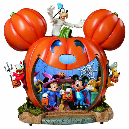Hand-crafted 16 inch orange Disney pumpkin house illuminated with internal LED lights featuring detailed Mickey and Friends figurines on an entryway console table.