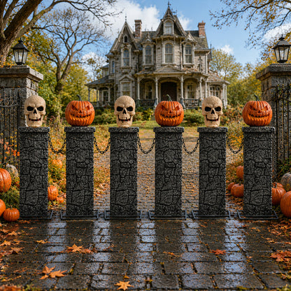 Samuel Alexander 2.4m battery powered Halloween fence featuring stone-effect tombstone pedestals with lit skull and pumpkin tops linked by black chains on a dark lawn.