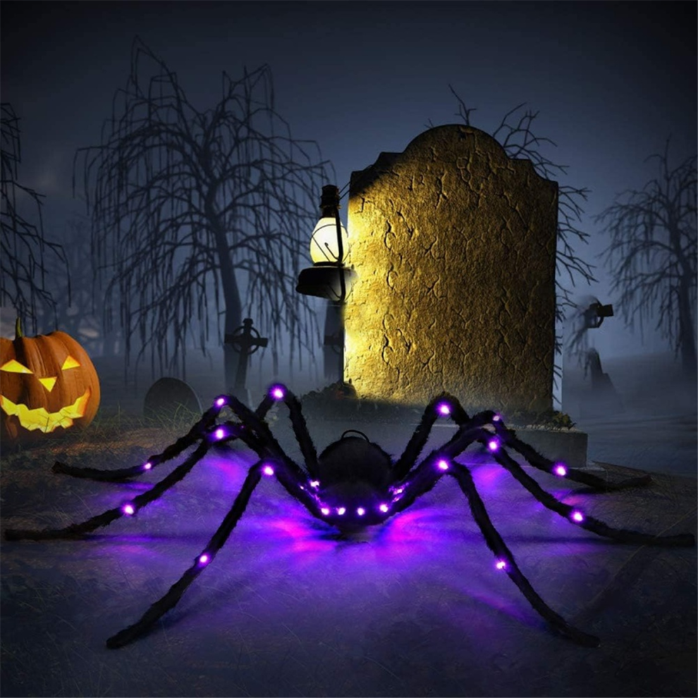A 2.9ft large hairy black spider with glowing LED eyes clinging to a spooky web outdoors during Halloween night.