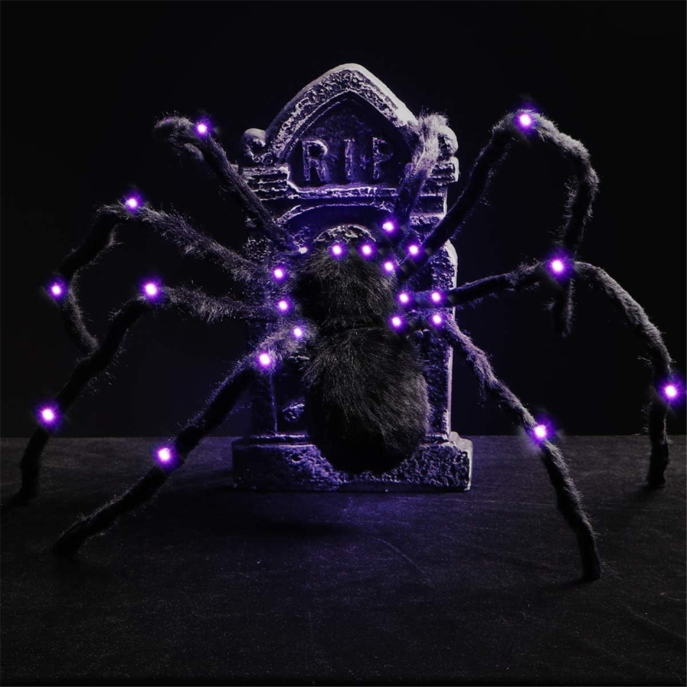 A 2.9ft large hairy black spider with glowing LED eyes clinging to a spooky web outdoors during Halloween night.