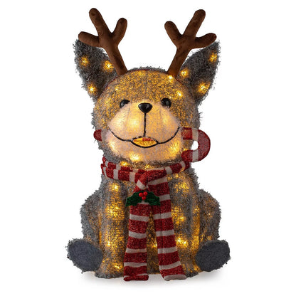 Three illuminated outdoor LED Christmas dog figures standing on a green lawn wearing festive scarves and headbands at twilight.