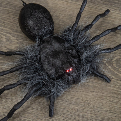 Black faux-fur animatronic spider with glowing red eyes hanging from a suspended string against a dark background.
