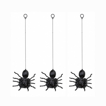 Black faux-fur animatronic spider with glowing red eyes hanging from a suspended string against a dark background.