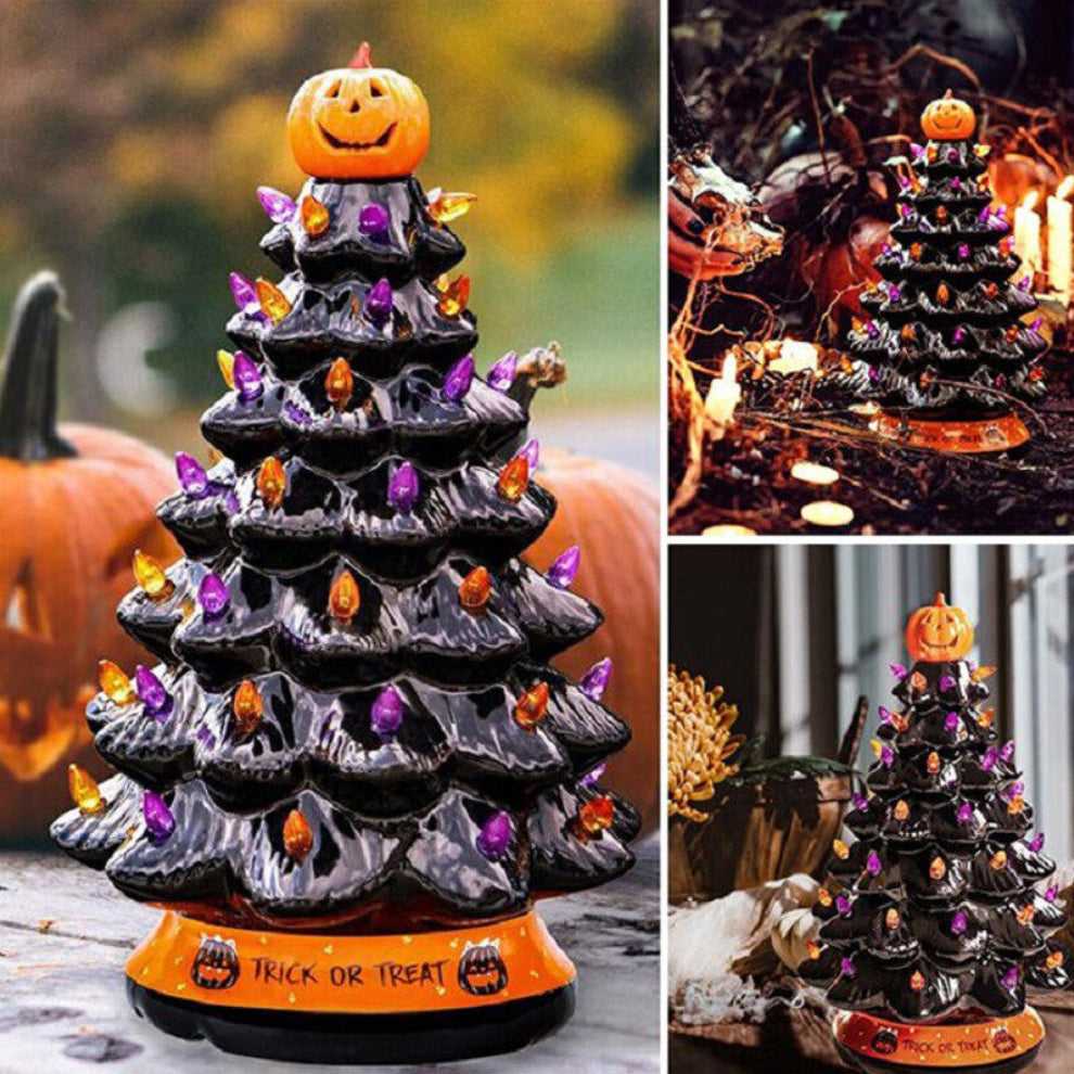 A 30cm black tabletop Halloween tree decorated with glowing pumpkin LED lights and warm white flashing beads sitting on a festive wooden surface.
