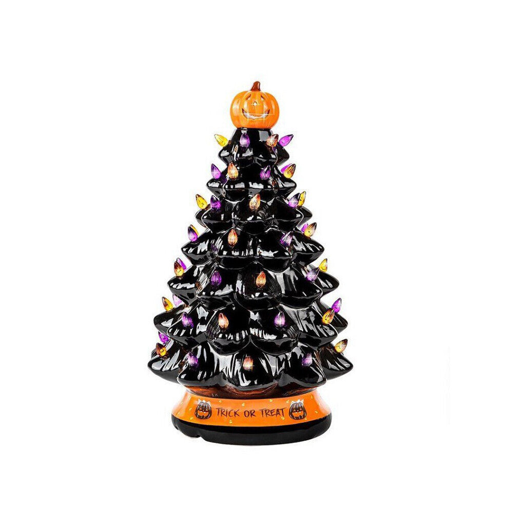 A 30cm black tabletop Halloween tree decorated with glowing pumpkin LED lights and warm white flashing beads sitting on a festive wooden surface.