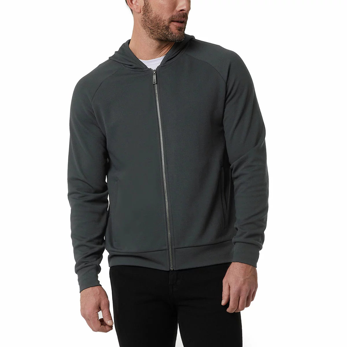 Front view of a man wearing the textured 32 Degrees Pique Full Zip Hoodie featuring zippered hand pockets in a modern casual setting