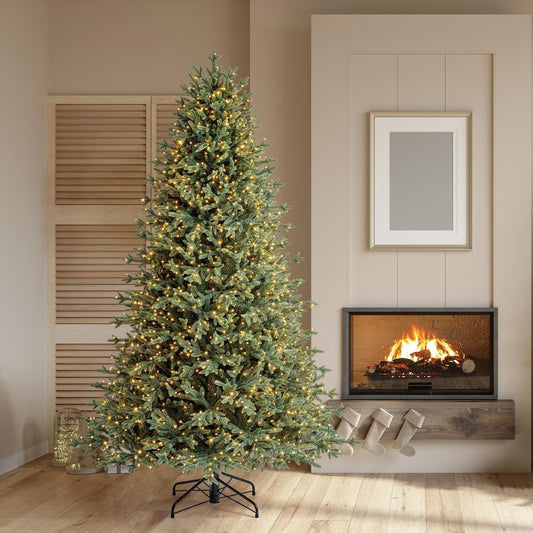 7.5ft pre-lit Aspen artificial Christmas tree lit warm white beside a fireplace