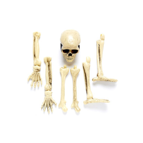 Front angle view of a weathered resin 3D Skeleton Groundbreaker emerging from damp green lawn soil at dusk.