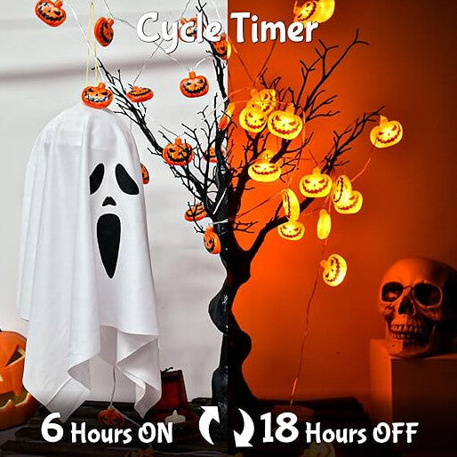 A 3M string of 20 3D pumpkin LED lights glowing with a warm orange light across a decorated indoor window.