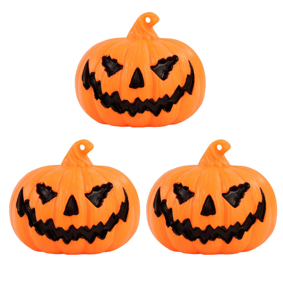 A set of three durable plastic Halloween LED light-up pumpkin lanterns featuring terror face designs glowing softly on a festive party table.