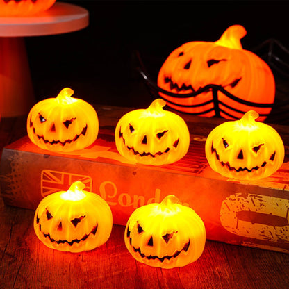 A set of three durable plastic Halloween LED light-up pumpkin lanterns featuring terror face designs glowing softly on a festive party table.