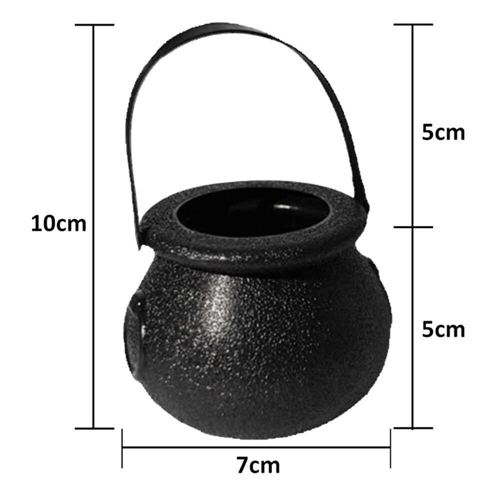 A group of mini black plastic witch candy cauldrons with curved handles arranged on a table filled with Halloween treats.