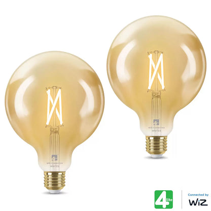 A pair of 4lite WiZ Connected E27 Amber Filament Smart Bulbs glowing with a warm orange vintage light inside a contemporary living room setting.