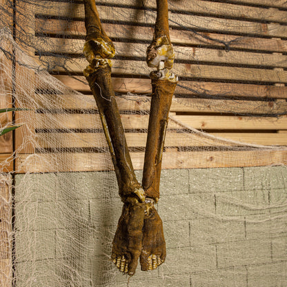 Front view of a 5ft tall brown mummified skeleton prop with posable joints and a distressed finish hanging against a dark background.