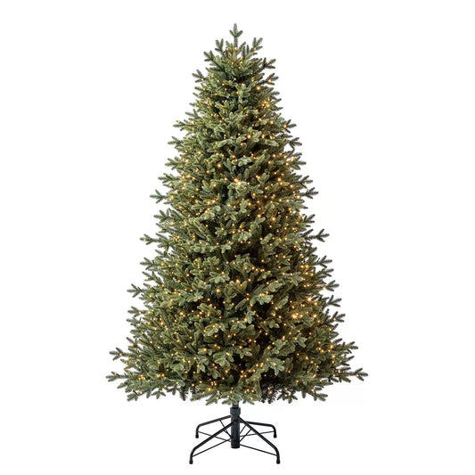 A full 6.5ft pre-lit Aspen artificial Christmas tree featuring dense pine tips and warm, glowing micro LED lights set on a metal stand in a cozy living room setting.