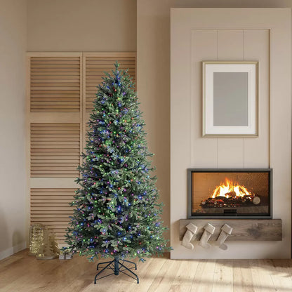 A 6.5ft pre-lit Aspen artificial Christmas tree featuring dense pine tips and glowing colour changing micro LED lights inside a cozy living room setting.