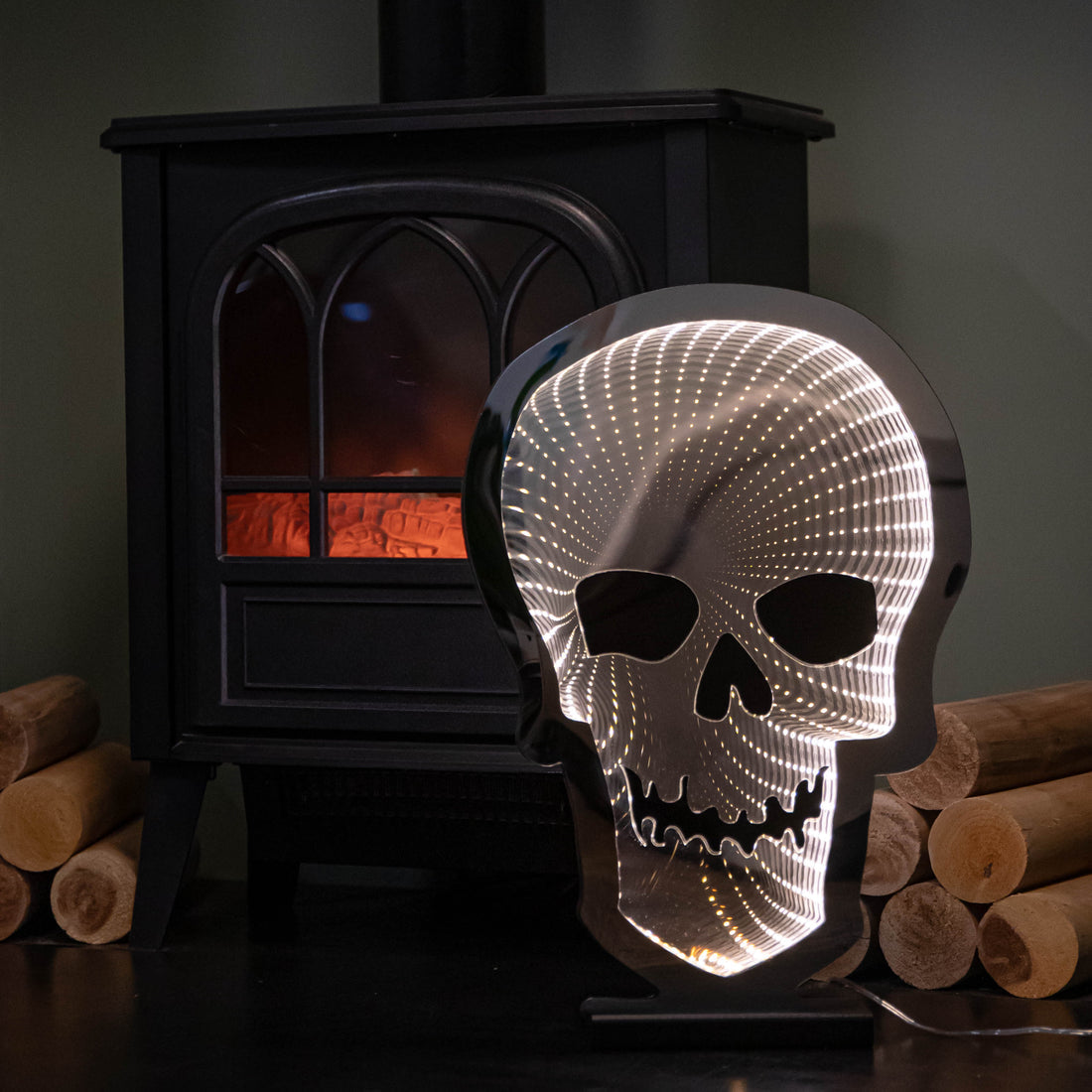 Samuel Alexander 60cm light up Halloween skull infinity light with warm white LEDs glowing on a wooden base in a darkened room setting.
