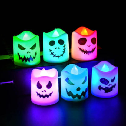 A set of 6 multicolor LED Halloween ghost and pumpkin tealight candles glowing warmly on a dark table setup for a party.