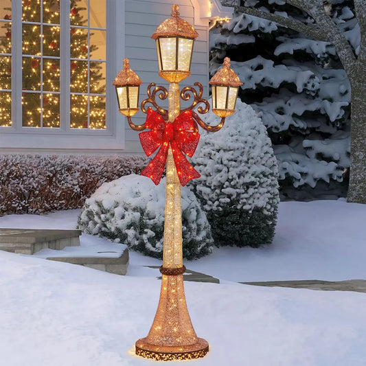Front view of a black 7ft Puleo Christmas lamp post illuminated with warm white LED lights standing outdoors on a patio at dusk.