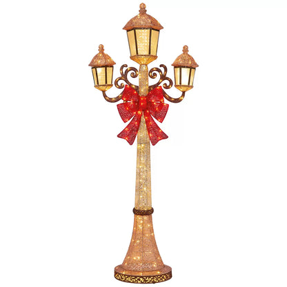 Front view of a black 7ft Puleo Christmas lamp post illuminated with warm white LED lights standing outdoors on a patio at dusk.