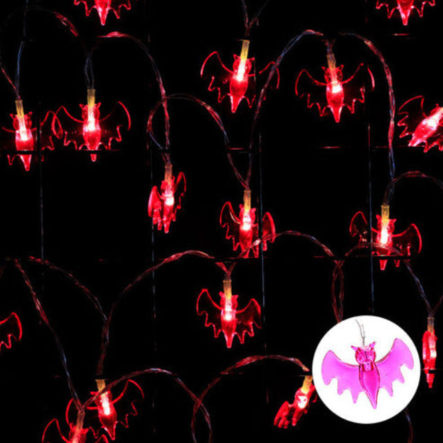 A 9.84ft string of 20 warm white LED Halloween lights glowing against a decorated indoor window display.