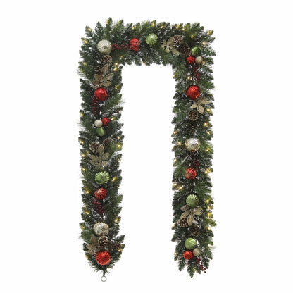 Close-up of a 9ft pre-lit artificial Christmas garland featuring 90 warm white glowing LED lights, realistic pine branches, pinecones, and red festive ornaments draped indoors.