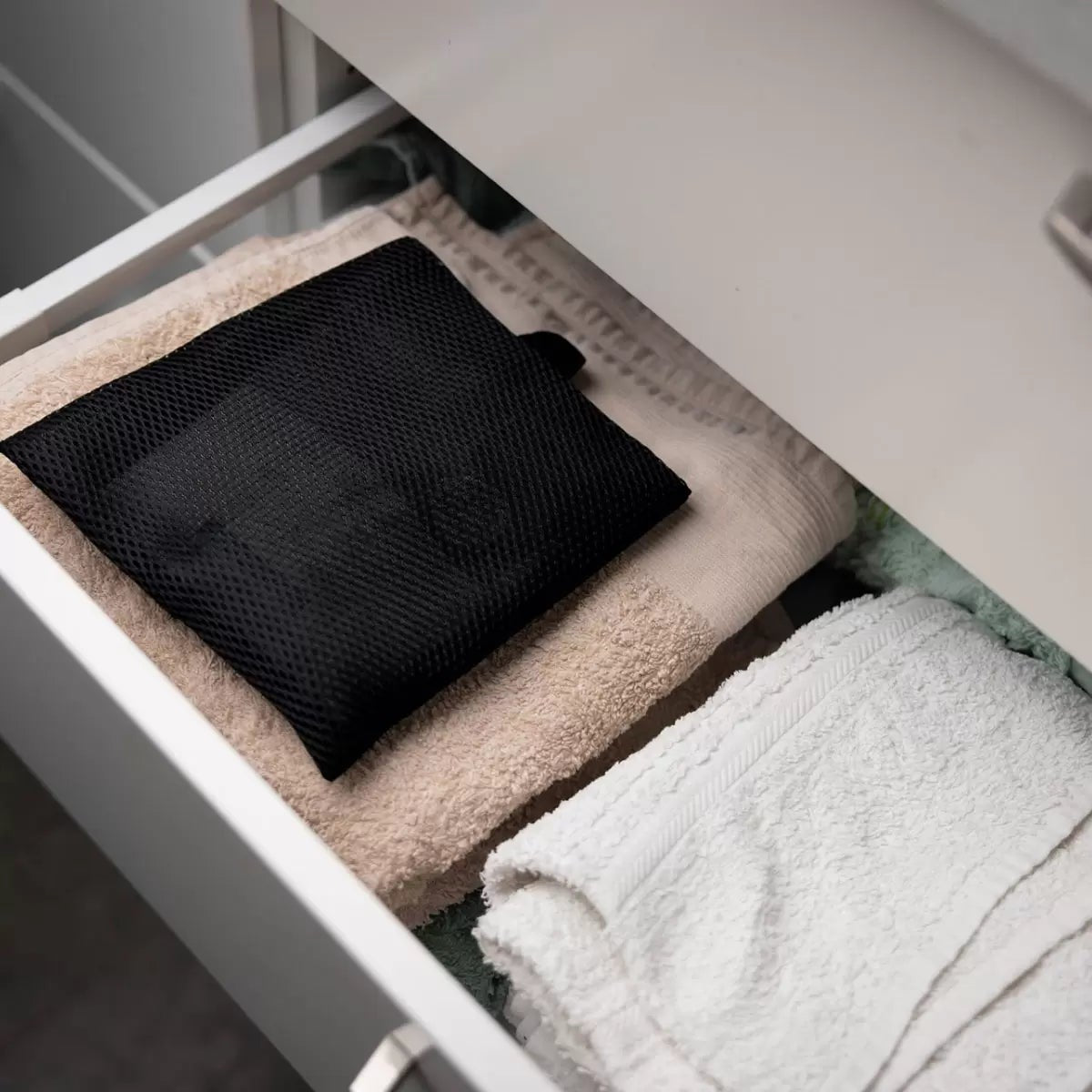 Front view of the minimalist Scandinavian Absodry Moisture Absorber unit next to a 600g refill pack and hanging textile wardrobe bag on a clean shelf.