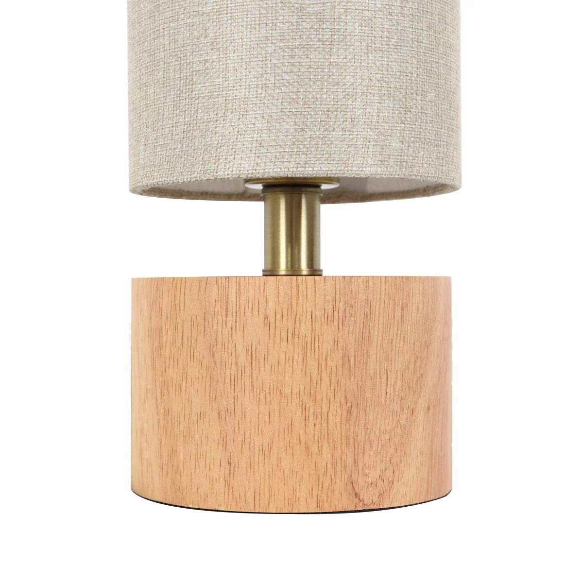 Natural rubberwood base of the Adesso Brayden table lamp with a beige fabric shade on a wooden side table.