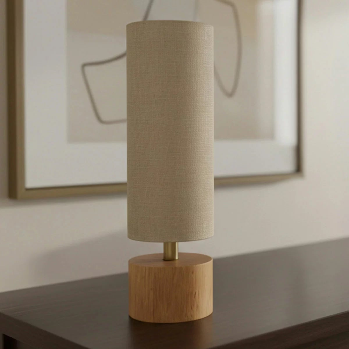 Natural rubberwood base of the Adesso Brayden table lamp with a beige fabric shade on a wooden side table.