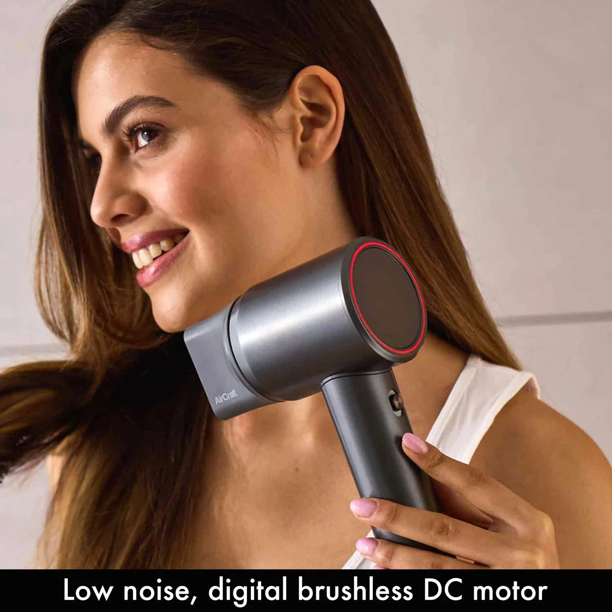 Side profile of the grey AirMotion Ionic hair dryer with its magnetic styling nozzle attached, set against a clean, modern bathroom background.