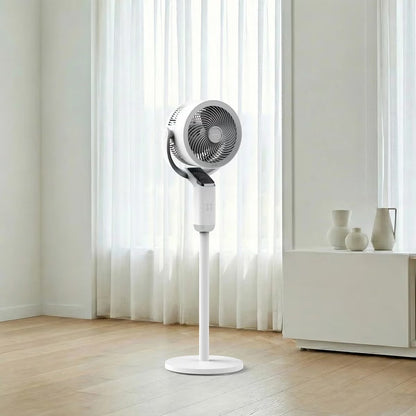 Modern white Airmate FA20-RD239 pedestal fan featuring a sleek slanted smart display screen, vertical support pole, and round base set in a sunlit living room.