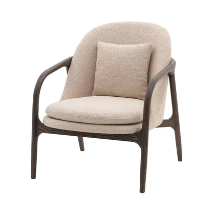 A front-three-quarter view of the Gallery Alegra taupe fabric armchair, showing its curved dark wood frame and comfortable padded taupe cushions in a sunlit room.