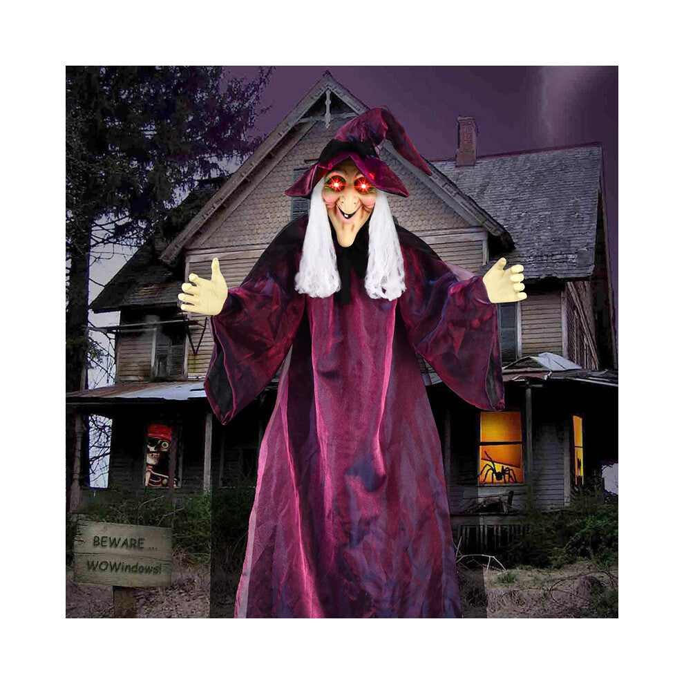 Hanging life-size Halloween animatronic witch in black yellow robes with glowing red LED eyes and grey hair.