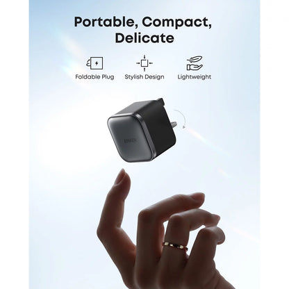 Two ultra-compact black Anker Nano 45W chargers showing their foldable metal pins, resting side-by-side on a modern office desk.