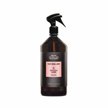 Front view of the 1 Litre Antiga 1860 Home Textile and Room Spray plastic bottle alongside its tall black luxury gift box on a clean surface.