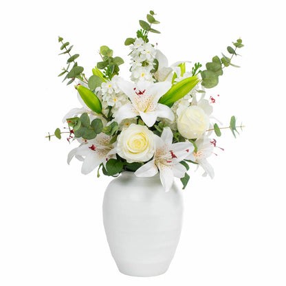 The Artificial Lily & Rose Bouquet in Vase displayed on a flat surface, showcasing vibrant fabric lilies and roses mixed with eucalyptus leaves inside a sleek white bowl.