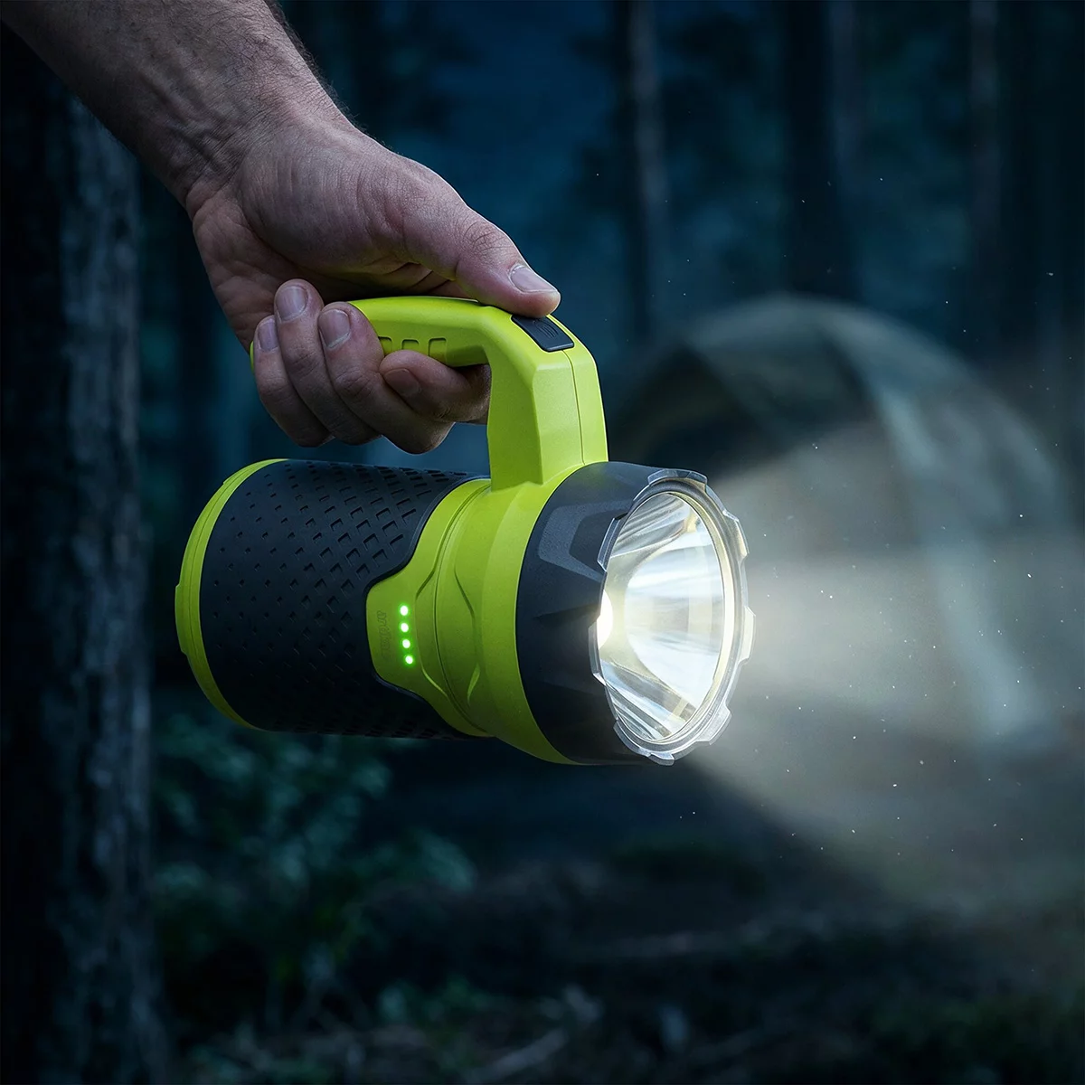 Black Artika Campa 4-in-1 modular portable outdoor kit set up on a rustic wooden picnic table at dusk, showing the illuminated lantern head and fan mounted on the dual-power stand.