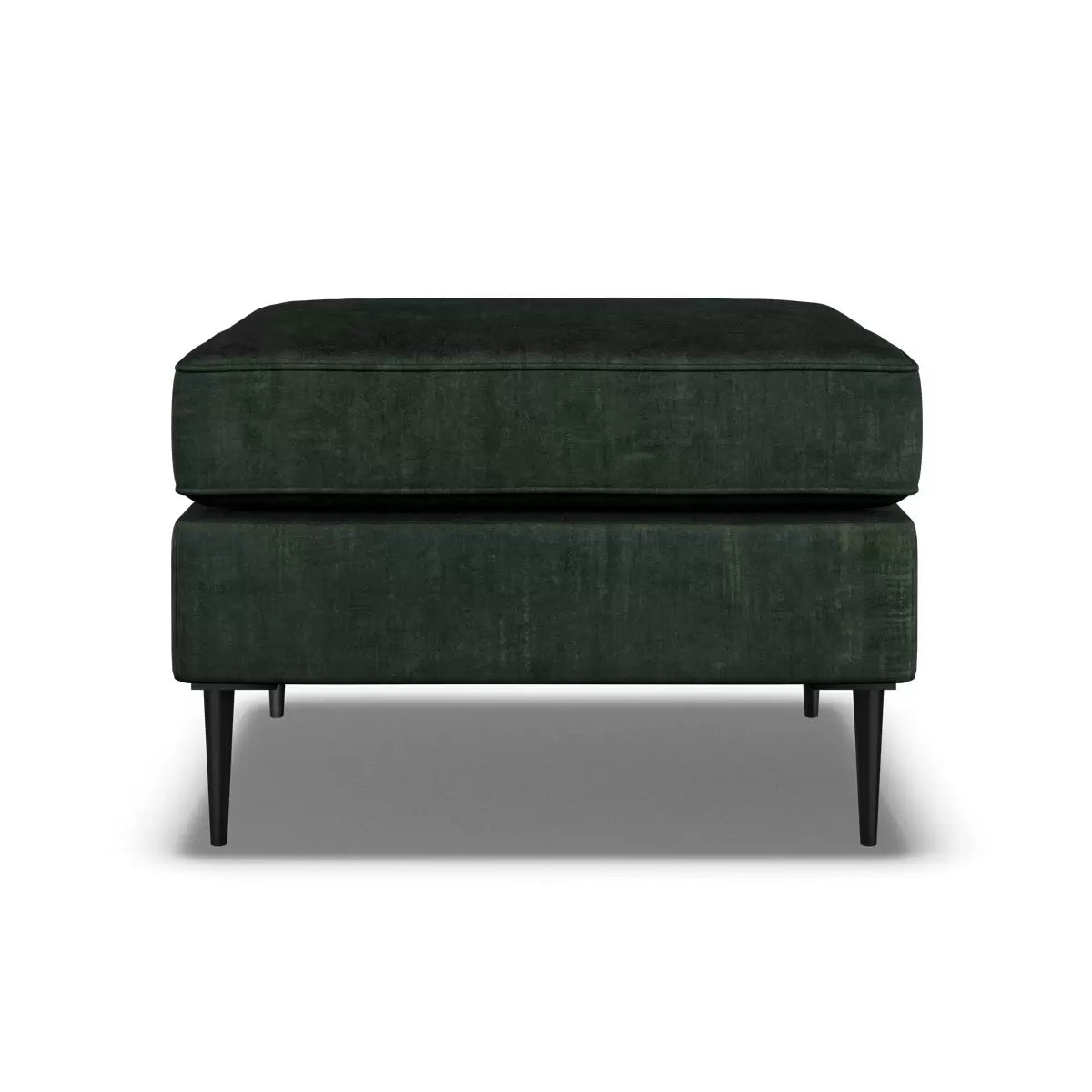 Top-angle view of the Aspen Green Velvet Footstool featuring rich emerald upholstery and sleek 18 cm black metal legs in a brightly lit modern living room setup.