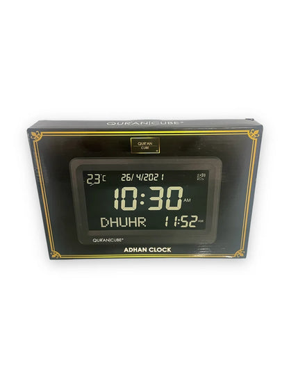Front view of the black digital Adhan clock resting on its table stand, displaying the time, current room temperature, and calculated prayer schedules in crisp digital numbers.
