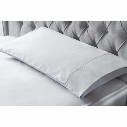 A pair of smooth, king-size Belledorm bamboo cotton pillowcases in a classic housewife cut, showcasing the silky fabric sheen in a naturally lit, minimal bedroom.