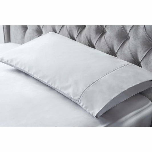 A pair of smooth, king-size Belledorm bamboo cotton pillowcases in a classic housewife cut, showcasing the silky fabric sheen in a naturally lit, minimal bedroom.