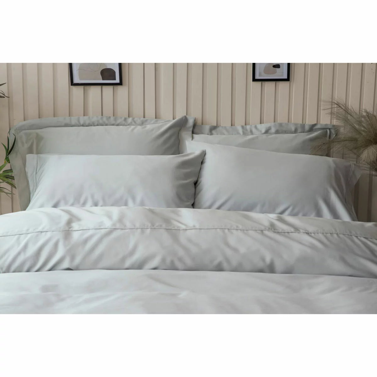 A pair of smooth, king-size Belledorm bamboo cotton pillowcases in a classic housewife cut, showcasing the silky fabric sheen in a naturally lit, minimal bedroom.