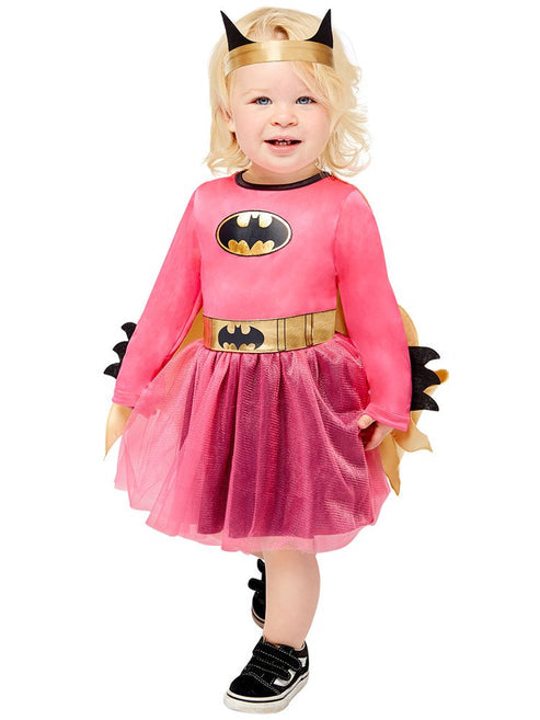 Front view of the pink Batgirl dress for toddlers featuring a yellow bat symbol, attached cape, matching arm gauntlets, and soft eye mask.