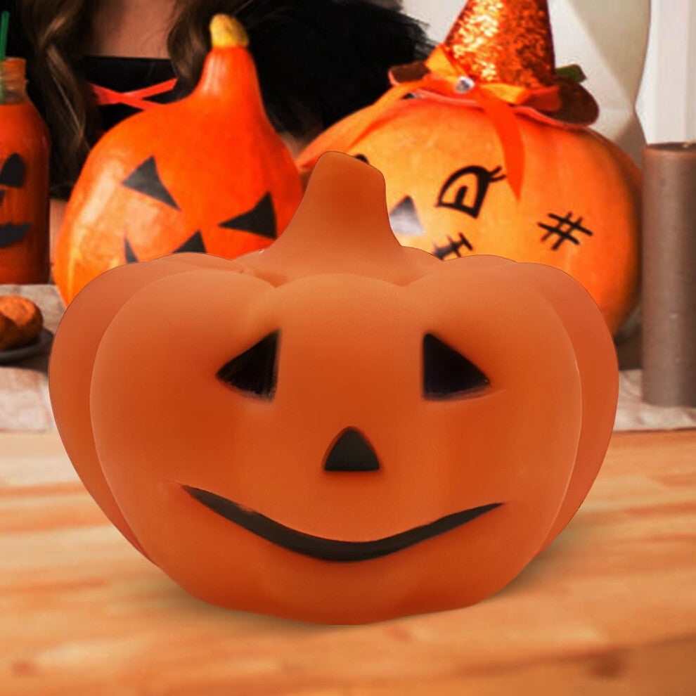A soft silicone LED pumpkin nightlight glowing gently on a child's bedside table with a cozy orange light.