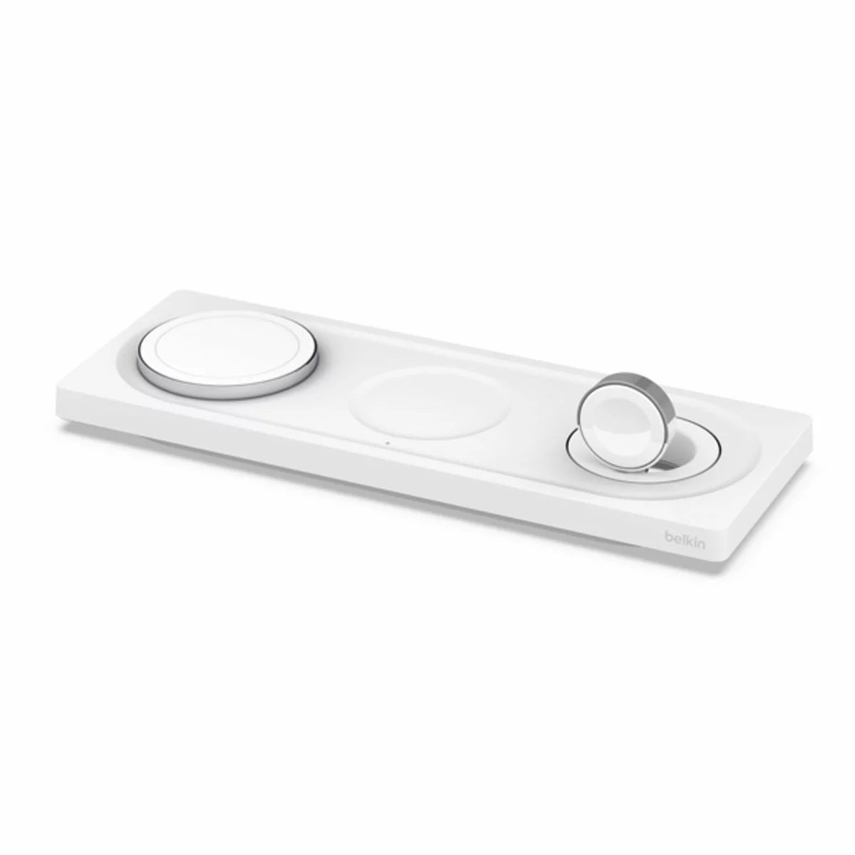 Top-down view of a white flat Belkin 3-in-1 MagSafe charging pad on a wooden table, simultaneously holding a modern smartphone, a smartwatch, and a wireless earbud case.