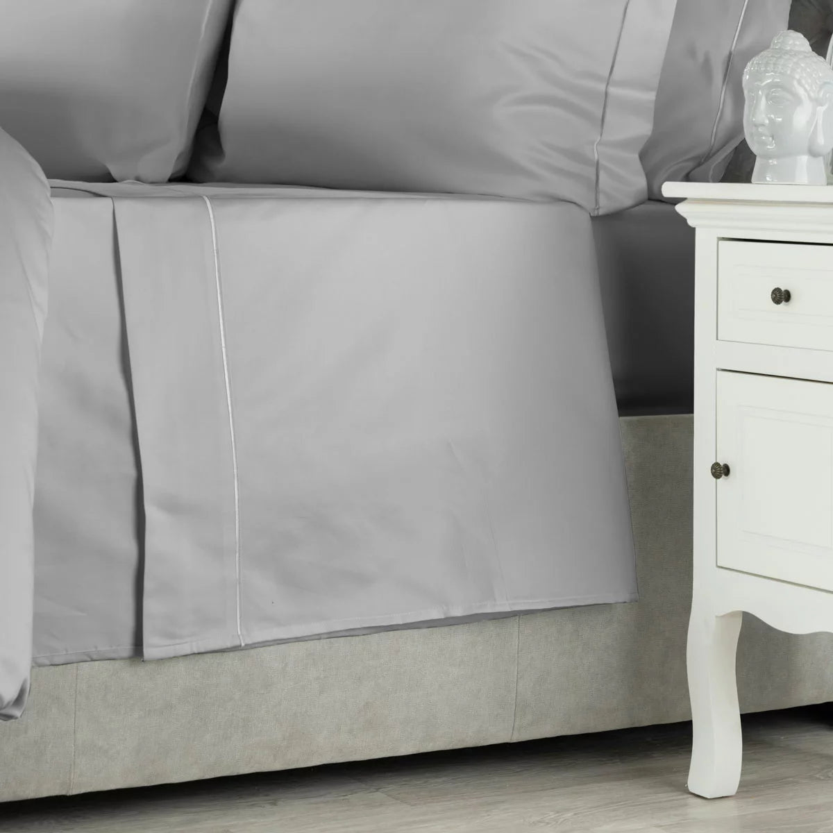 Folded Belledorm 1000 thread count platinum Egyptian cotton flat sheet showcasing the smooth sateen fabric sheen against a neutral mattress background.