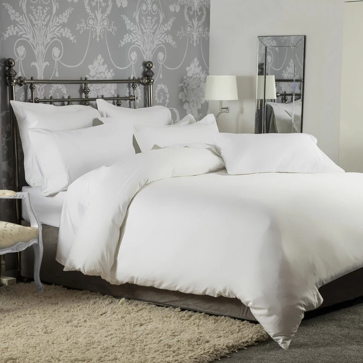 Close-up shot of the Belledorm 1200 thread count pure cotton sateen bedding bundle in bright white, showing the lustrous drape of the duvet cover and matching pillowcases on a neatly styled bed.